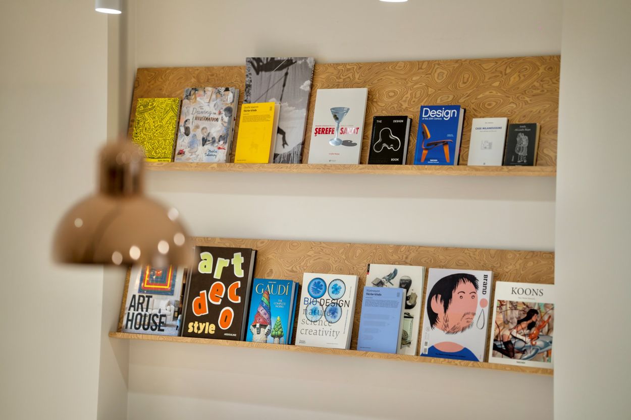 Ahşap kaplamalı kitap rafları ve bakır sarkıt aydınlatma